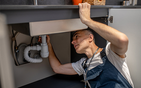 a man repair sink pipe